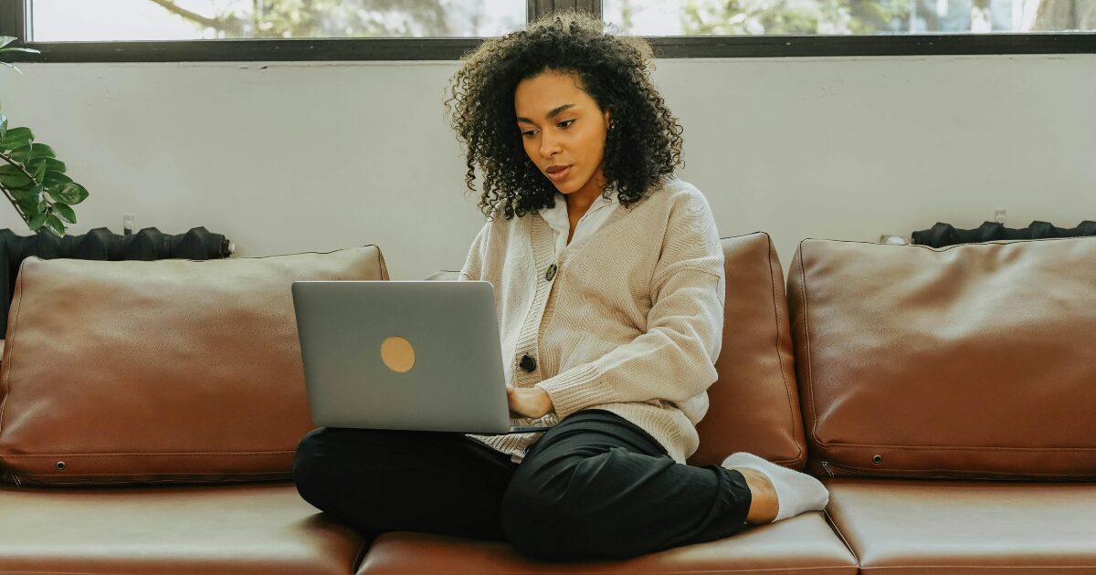 Young Black female in black sweatpants and a beige sweater.